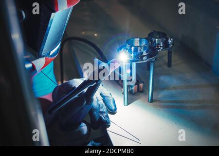 Männer Hände mit Argon Schweißmaschine. Reparatur Rohr Edelstahl Argon Schweißen Industriebau Stockfoto