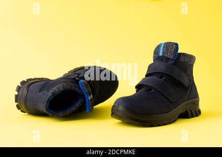 Dunkelblaue Herbst Herren Kinderstiefel auf gelbem Hintergrund, Copy Space Stockfoto