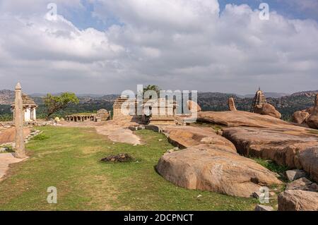 Hampi, Karnataka, Indien - 4. November 2013: Sunset Hill aka Hemakatu. Tempelruinen und Felsbrocken unter blauer Wolkenlandschaft. Stockfoto