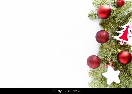Weihnachtskomposition. Weihnachtskugeln, Weihnachtsbaum aus Holz, flauschiger Stern, Tannenzweige auf weißem Hintergrund. Flach liegend, Draufsicht, Kopierbereich Stockfoto