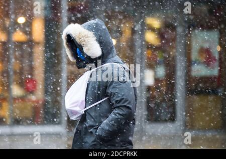 Toronto, Kanada. November 2020. Ein Mann mit Gesichtsmaske geht an einem verschneiten Tag in Toronto, Ontario, Kanada, am 22. November 2020 auf einer Straße. Umwelt Kanada hat am Sonntag für die meisten Gebiete im Süden Ontarios Schneefälle mit einem Schneefall von mehr als 20 cm prognostiziert. Quelle: Zou Zheng/Xinhua/Alamy Live News Stockfoto