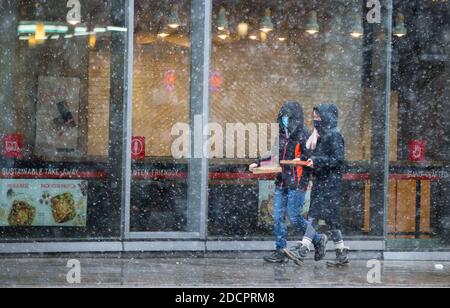 Toronto, Kanada. November 2020. Menschen mit Gesichtsmasken gehen an einem verschneiten Tag auf einer Straße in Toronto, Ontario, Kanada, 22. November 2020. Umwelt Kanada hat am Sonntag für die meisten Gebiete im Süden Ontarios Schneefälle mit einem Schneefall von mehr als 20 cm prognostiziert. Quelle: Zou Zheng/Xinhua/Alamy Live News Stockfoto