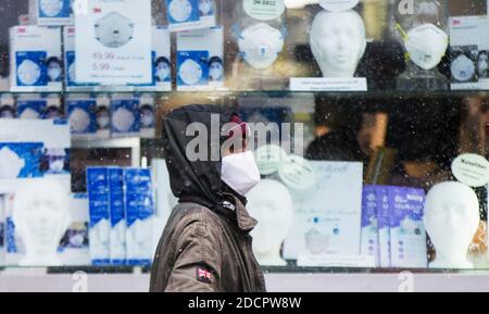 Peking, Kanada. November 2020. Ein Mann, der eine Gesichtsmaske trägt, geht an einem Geschäft vorbei, das Gesichtsmasken in Toronto, Kanada, am 22. November 2020 verkauft. Quelle: Zou Zheng/Xinhua/Alamy Live News Stockfoto