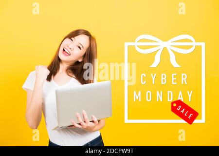 Asiatisch glücklich Porträt schön niedlich junge Frau teen Lächeln stehen Halten Sie Ihren Laptop bereit, und feiern Sie mit Cyber Monday den Erfolg In das Geschenk Stockfoto