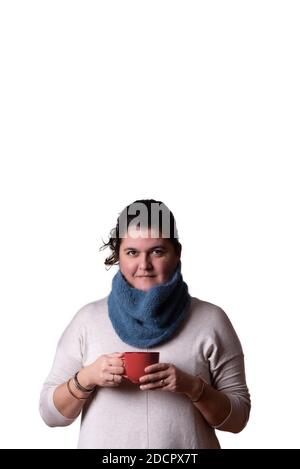 Vertikales Porträt einer Frau, die auf weißem Hintergrund eine rote Tasse Tee in den Händen hat. Winterkonzept. Speicherplatz kopieren Stockfoto