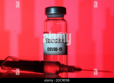 Ukraine. November 2020. In dieser Abbildung ist eine medizinische Spritze und ein Fläschchen mit COVID-19 Coronavirus-Impfstoff auf rotem Hintergrund zu sehen. Kredit: SOPA Images Limited/Alamy Live Nachrichten Stockfoto