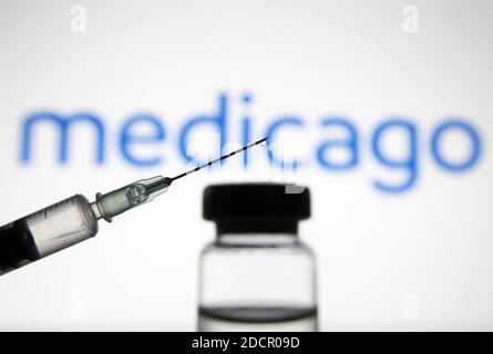 Ukraine. November 2020. In diesem Foto Illustration eine medizinische Spritze und ein Fläschchen mit COVID-19 Coronavirus-Impfstoff vor dem Medicago Biotechnologie Unternehmen Logo gesehen Kredit: SOPA Images Limited/Alamy Live News Stockfoto