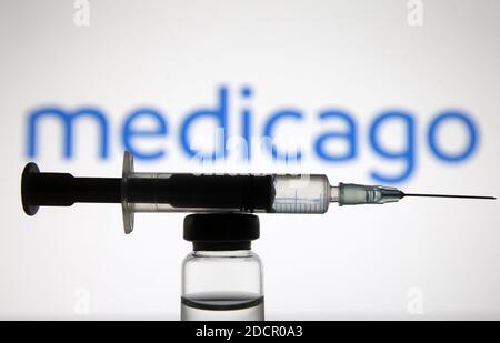 Ukraine. November 2020. In dieser Abbildung sehen Sie eine medizinische Spritze und eine Ampulle mit COVID-19-Coronavirus-Impfstoff vor dem Firmenlogo von Medicago Biotechnology. Kredit: SOPA Images Limited/Alamy Live Nachrichten Stockfoto