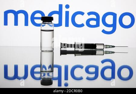 Ukraine. November 2020. In diesem Foto Illustration eine medizinische Spritze und ein Fläschchen mit COVID-19 Coronavirus-Impfstoff vor dem Medicago Biotechnologie Unternehmen Logo gesehen Kredit: SOPA Images Limited/Alamy Live News Stockfoto