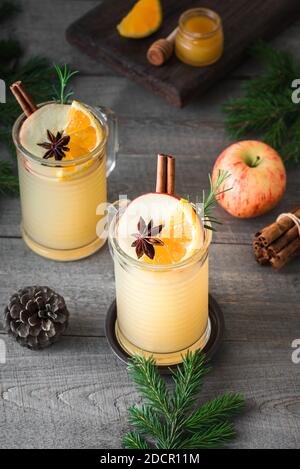 Heiße Rum-, Whiskey- oder Brandy-Apfel-Toddy-Cocktail-Drinks auf rustikalem Holztisch. Saisonaler Winter oder Weihnachten heiß würzigen Getränk, Glühmost. Stockfoto