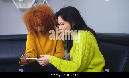 Ungewollte Schwangerschaftskonzept. Die besten Freunde waren mit einem positiven Schwangerschaftstest enttäuscht. Hochwertige Fotos Stockfoto