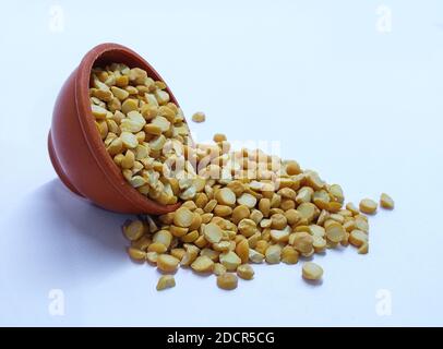 Gelbe Linse in Schüssel isoliert auf weißem Hintergrund mit Clipping Pfad. Um eine traditionelle vegetarische indische gewürzte Suppe-Püree Chana dal vorzubereiten. Stockfoto