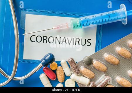 Neue Coronavirus-Krankheit 2019-nCoV auf blauer Mappe geschrieben. Viele Pillen, Spritze und Stethoskop. Stockfoto