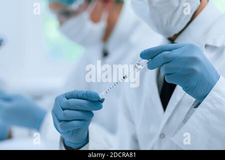 Nahaufnahme. Spritze mit einem neuen Impfstoff in den Händen eines Sanitäter. Stockfoto