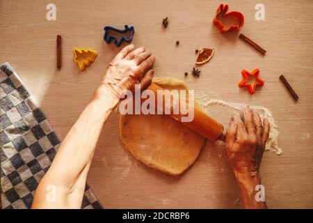 Hände Rollen den Teig mit einem Nudelholz, Draufsicht. Hausgemachte Kekse. Stockfoto