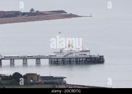 Menschen, die an einem kalten Wintertag entlang der Strandpromenade in der Nähe von Eastbourne Pier und Strand spazieren. Quelle: James Boardman Stockfoto