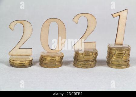 2021 in Holzfiguren und immer mehr Euro-Münzen Stockfoto
