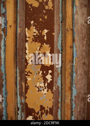 Strukturierter Hintergrund/Hintergrund aus verwittertem rustikalem Holz mit dunkelroter, oranger und hellblauer Farbe, die sich als Hintergrund ablöst Stockfoto