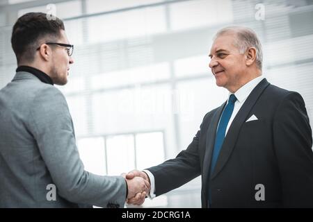 Firm Business Handshake auf einem verschwommenen Bürohintergrund. Stockfoto
