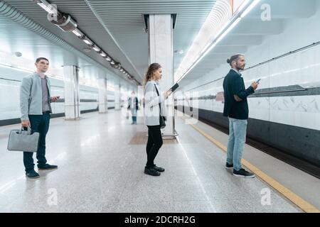 U-Bahn-Passagiere warten auf den Zug auf dem Bahnsteig. Stockfoto