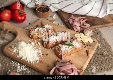 Bruschetta: Hausgemachter Schafskäse, Speck, Sauerkraut, Knoblauch, selbstgebackenes Brot, Kräuter und Gewürze. Italienisches Essen. Stockfoto