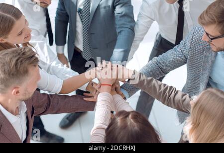 Gruppe von jungen Geschäftsleuten, die ihre Hände zusammenlegen. Stockfoto