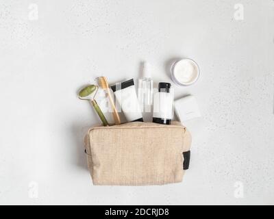 Öko Reise Kosmetiktasche mit den notwendigen Mitteln, um die Haut der Frauen zu pflegen. Kosmetik, Massagegerät mit Kristallen, Trockenshampoo, Wattestäbchen, Zahnbürsten i Stockfoto