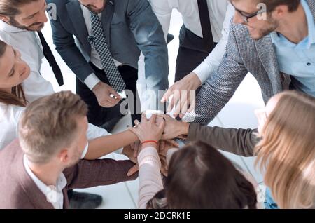 Gruppe von jungen Geschäftsleuten, die ihre Hände zusammenlegen. Stockfoto