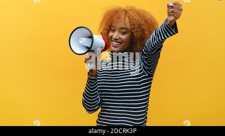 afroamerikanische schwarze Frau mit lockigen Haaren, die in den Lautsprecher schrie. Hochwertige Fotos Stockfoto