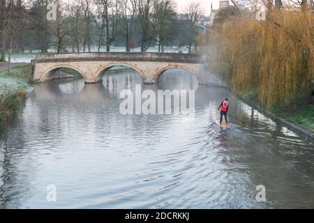 Cambridge, Großbritannien. November 2020. Ein Mann fährt an einem frostigen Morgen mit einem Stand Up Paddle Board durch den Nebel auf der River Cam an der Trinity College Brücke. Die Temperaturen waren fast eiskalt und es gab weit verbreiteten Frost und Nebel zu Beginn eines sonnigen Spätherbsttages. Kredit: Julian Eales/Alamy Live Nachrichten Stockfoto