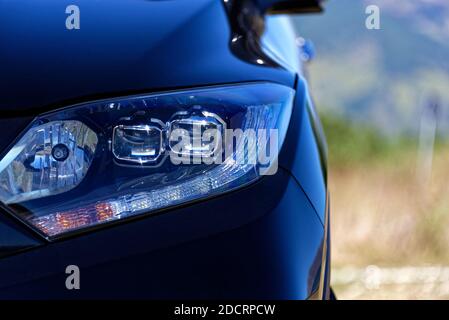 Nahaufnahme des vorderen Teils des Fahrzeugs mit dem Scheinwerfer, schwarzes Fahrzeugbild Stockfoto