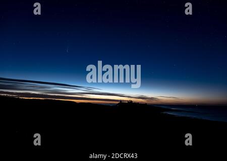 Eine Spätsommernacht in Northumberland mit Blick nach Norden über Dunstanburgh Castle. Stockfoto