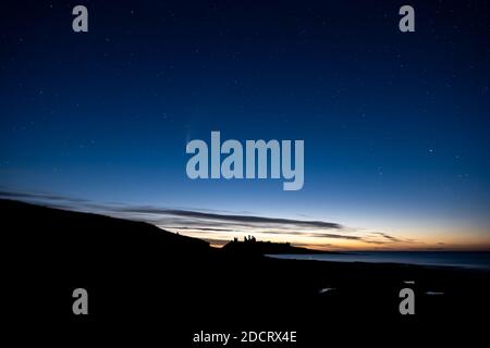 Eine Spätsommernacht in Northumberland mit Blick nach Norden über Dunstanburgh Castle. Stockfoto