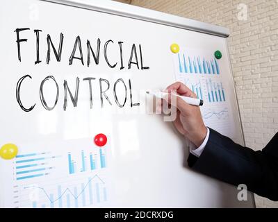 Der Wirtschaftsprüfer schreibt die Worte Finanzkontrolle auf das Whiteboard. Stockfoto