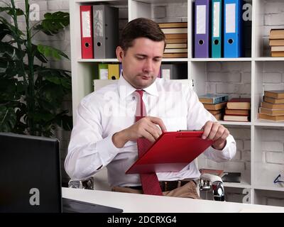 Der Manager im Büro füllt die Formulare aus. Papierarbeit. Stockfoto