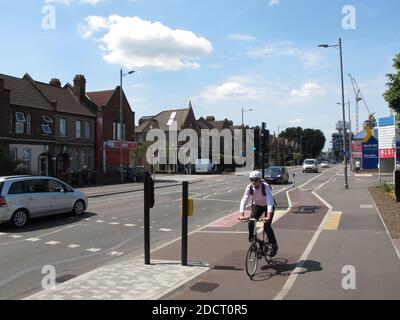 Ein Radfahrer nutzt die neue Fahrradspur auf der Lea Bridge Road, London, Großbritannien. Teil des Mini Holland-Programms von Waltham Forest für sichereres Radfahren. Stockfoto