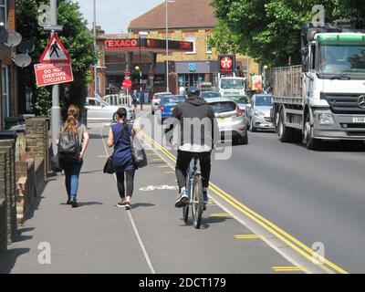 Ein Radfahrer nutzt die neue Fahrradspur auf der belebten Markhouse Road, London, Großbritannien. Teil des Mini Holland-Programms von Waltham Forest für sicherere Straßen. Stockfoto