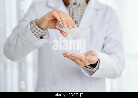 Arzt, der Gel-Händedesinfektionsmittel anwendet Stockfoto