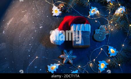 Geschenkbox in Weihnachtsmütze auf Weihnachtstisch mit Copyspace Stockfoto