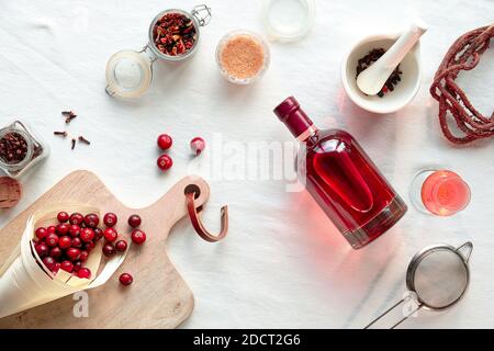 Hausgemachte alkoholische Getränke Vorbereitung. Flach liegend, Draufsicht auf selbst gemachte Cranberry Tinktur. Stockfoto