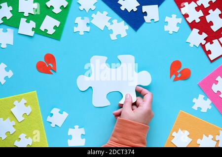 Autismus-Bewusstsein-Konzept. Flach Lay, Hand, Puzzle-Stücke. Textbereich auf blauem Hintergrund. Stockfoto