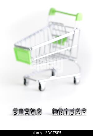 Nahaufnahme am Black Friday geschrieben mit Metallwürfeln mit einem Supermarkt Trolley im Hintergrund Stockfoto