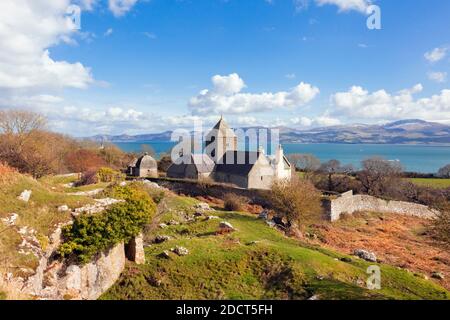 Penmon Priorat (St. Seiriols Kloster) und Blick auf die Küste von Nord-Wales über die Menai Strait. Penmon, Isle of Anglesey (Ynys Mon), Nordwales, Großbritannien Stockfoto