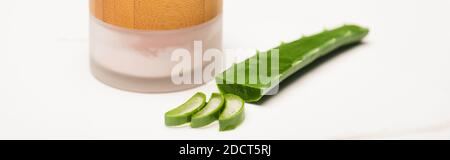 Behälter von natürlichen hausgemachten kosmetischen Creme in der Nähe geschnitten Aloe Vera Blatt und Scheiben auf weiß, Banner Stockfoto