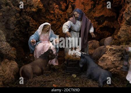 Weihnachtskrippe Statuen mit der seligen Jungfrau Maria, St. Joseph auf der Krippe mit Ochsen und Esel in der Nähe nach dem Heiligen Kind Jesus Stockfoto