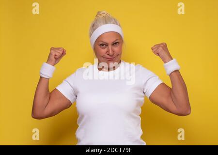 Ältere Frau mit Armmuskulatur, selbstbewusst und stolz auf Macht Stockfoto