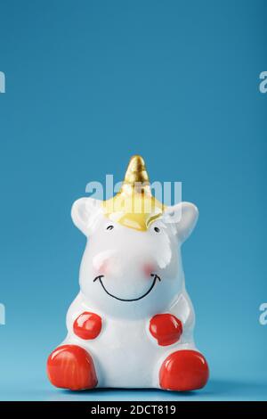 Einhorn-Figur auf blauem Hintergrund mit freiem Platz. Symbol für Glück und Erfolg. Stockfoto