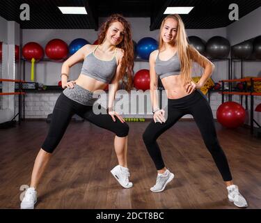 Zwei junge Fitness-Mädchen posieren im Tanzstudio Stockfoto