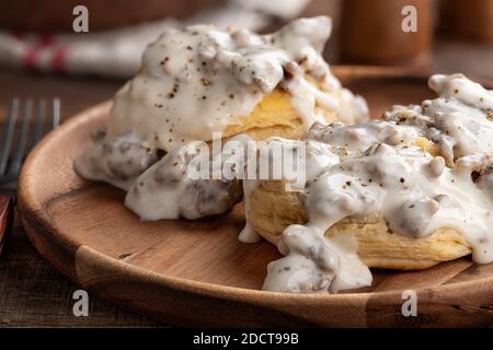 Nahaufnahme von Keksen und cremiger Wurstsoße auf einem hölzernen Platte Stockfoto