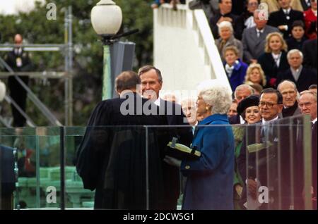 US-Präsident George H.W. Bush wird am 20. Januar 1989 vom Oberrichter William Rehnquist im US-Kapitol als 41. Präsident der Vereinigten Staaten vereidigt. First Lady Barbara Bush (trägt einen blauen Mantel) schaut auf, während sie die familienbibel hält. Zu den erkennbaren Kongressmitgliedern auf der rechten Seite gehören US-Senator Ted Stevens (Republikaner von Alaska), US-Senator Alan Simpson (Republikaner von Wyoming) und der Sprecher des US-Repräsentantenhauses Jim Wright (Demokrat von Texas). Foto von Ron Sachs / CNP /ABACAPRESS.COM Stockfoto